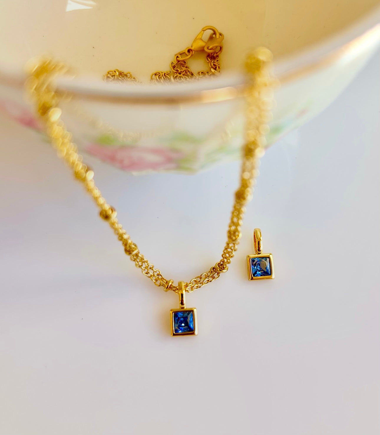 Gold September birthstone pendant necklace with sapphire deep blue gemstone