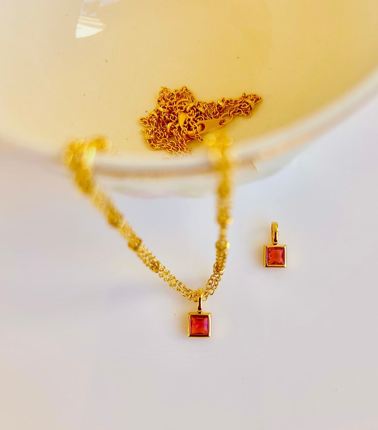 Gold July birthstone pendant necklace with ruby red gemstone