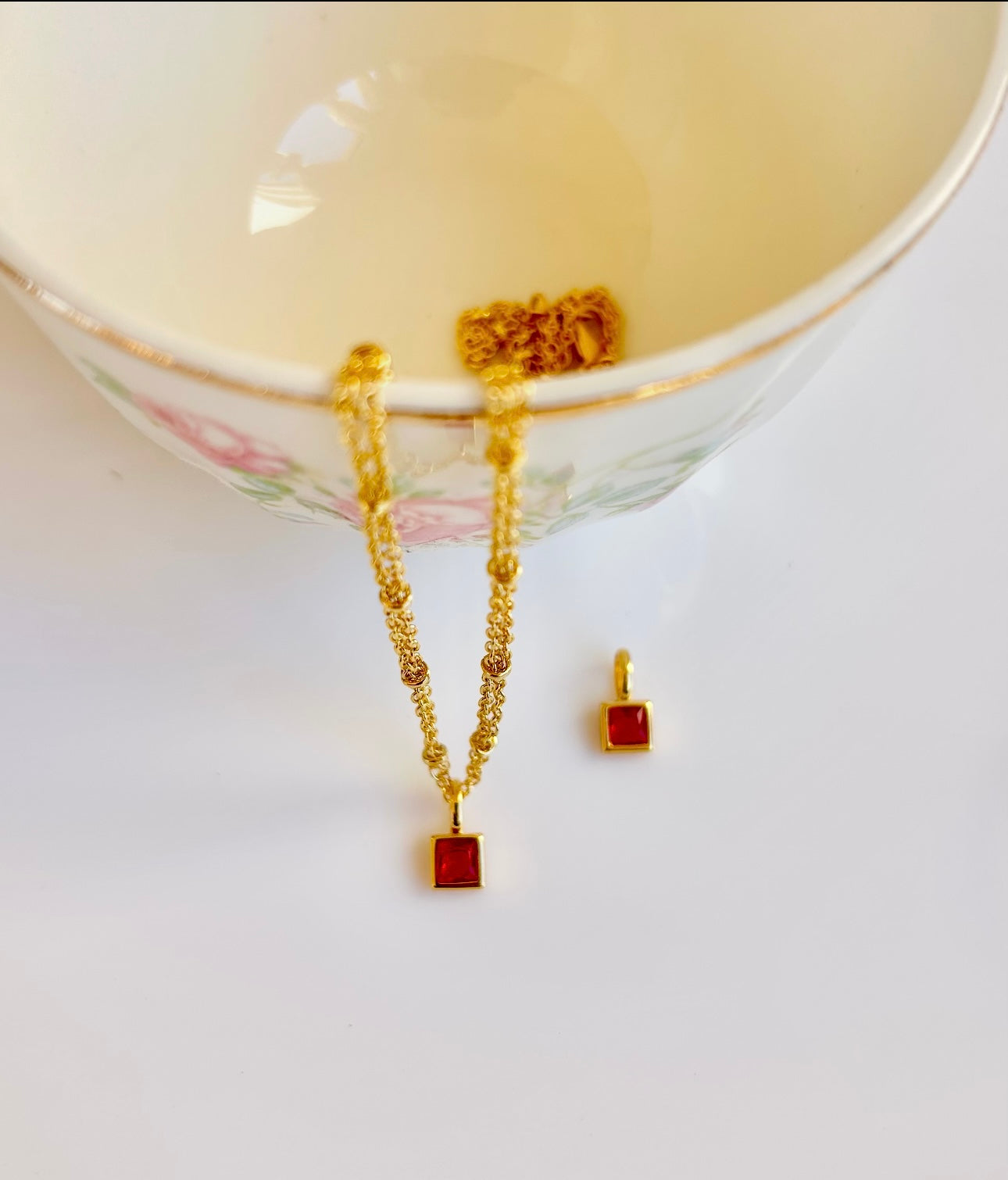 Gold January birthstone pendant necklace with garnet red gemstone